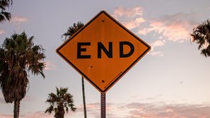 A traffic end sign before the backdrop of a sundown